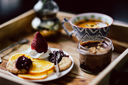 Room service tray at hotel for breakfast: cookies, jam, chocolate mousse, orange fruit, tea thumbnail
