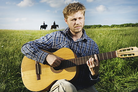 man playing guitar on grass thumbnail