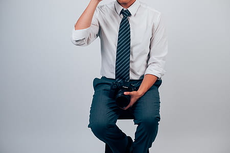 man sitting on stool wearing white dress shirt and grey dress pants thumbnail