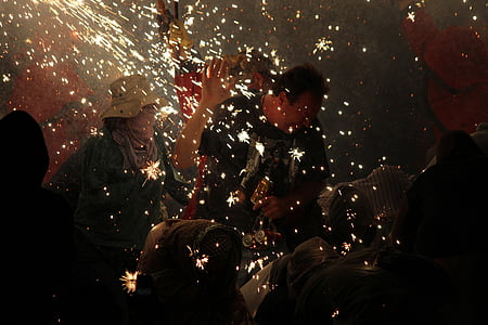 man standing surrounded with people lighting sparklers thumbnail