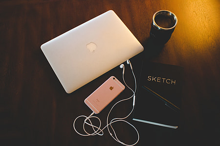 Laptop, sketchbook and iPhone mobile smartphone on a desk thumbnail