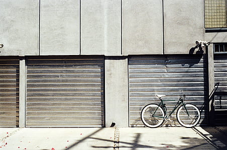 black bicycle parked in front of garage door thumbnail