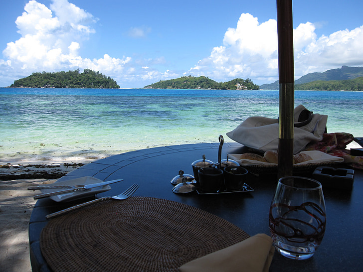 clear drinking glass on table near seashore during daytime