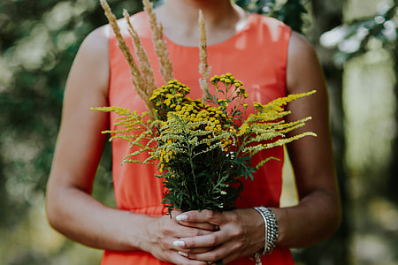Woman in a red dress with flowers outdoors thumbnail