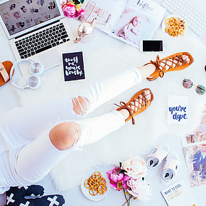 person wearing distressed white denim jeans and brown strappy flat sandals thumbnail