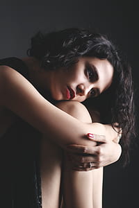 close-up photography of woman holds both knee thumbnail