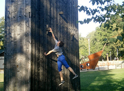 man in gray shirt on wall climbing during daytime thumbnail