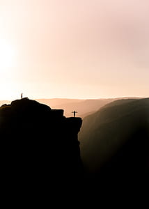 silhouette of two persons standing on cliff during daytime thumbnail