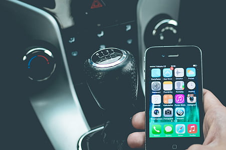 person holding a black iPhone 4 while inside a car thumbnail