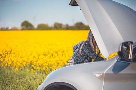 Young Woman Trying to Check and Repair Her Broken Car thumbnail