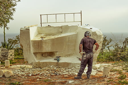 man standing near rock formation during daytime thumbnail