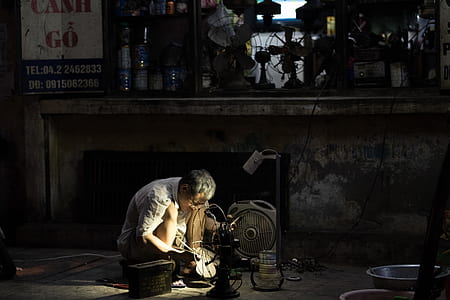 man repairing fan beside a concrete sideboard thumbnail