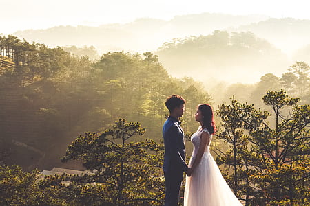 bride and groom standing with green trees as background thumbnail