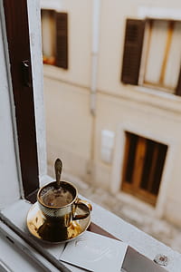 Drink coffee in a golden cup at the window thumbnail