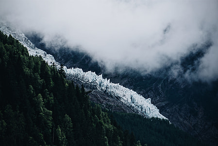 snow covered mountain with densed fog during daytime thumbnail