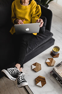 Young woman sitting on the sofa and working on her laptop thumbnail