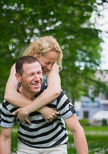 woman on back of man while smiling thumbnail