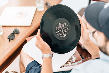 man in white shirt holding vinyl record player thumbnail