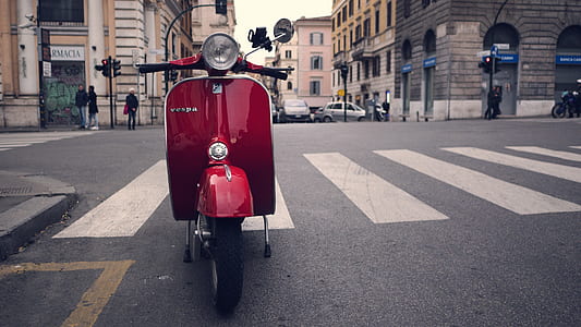 red motor scooter park on concrete road near pedestrian lane during daytime thumbnail