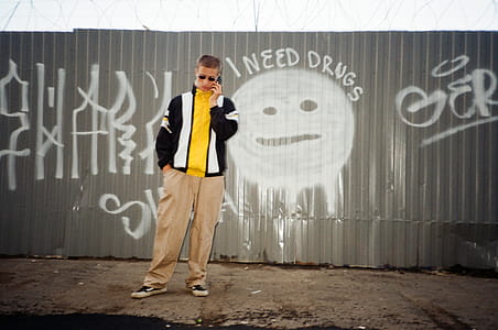 Man Standing Near Wall Holding Phone thumbnail