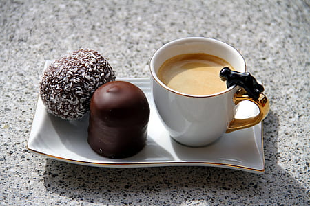 liquid filled ceramic mug beside cakes on tray thumbnail