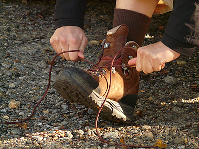 person tying brown boots during daytime thumbnail