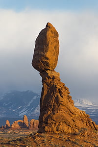 brown stone formation near snowy mountains landscape photography thumbnail