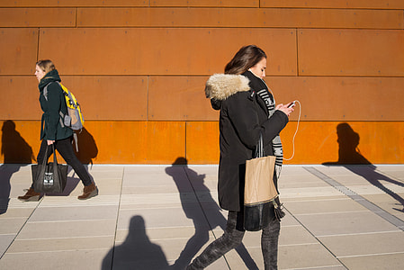 Street shot of a young woman using her mobile iPhone smartphone in Vienna, Austria thumbnail