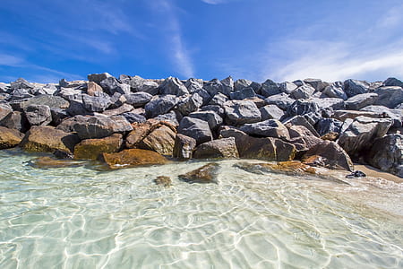 rock formation on body of water during daytime thumbnail