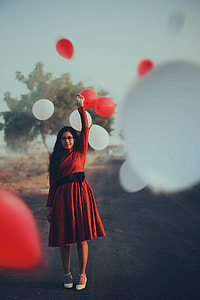 woman in red long-sleeved midi dress holding balloon during daytime thumbnail