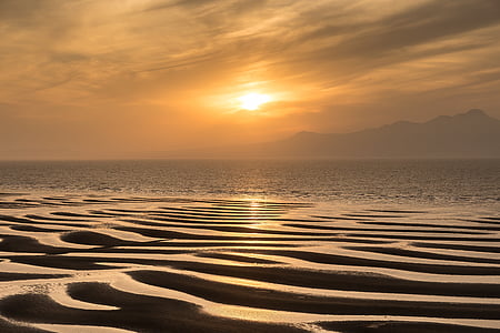 calm body of water overlooking mountain golden hour photography thumbnail