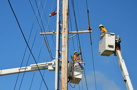 two men in bucket lifters near electric cables thumbnail
