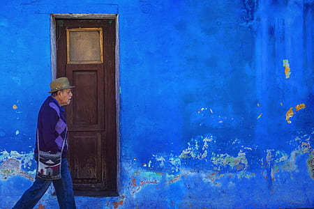 man walking near blue building at daytime thumbnail