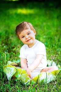 smiling baby sitting on green grass thumbnail