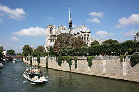 white riverboat crossing beside brown concrete wall thumbnail