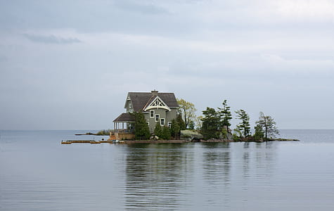 white and brown wooden house in front of lake photography thumbnail