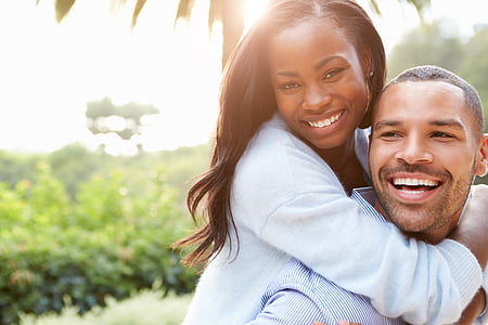 shallow depth of field photo of man carrying woman on his back thumbnail