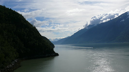 calm body of water surrounded by mountains at daytime thumbnail