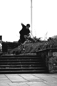 Grayscale Photo of Man Doing Trick on Skateboard on Park thumbnail