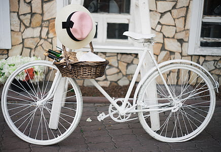 white and pink hat hanged on white bike near white stand at daytime thumbnail