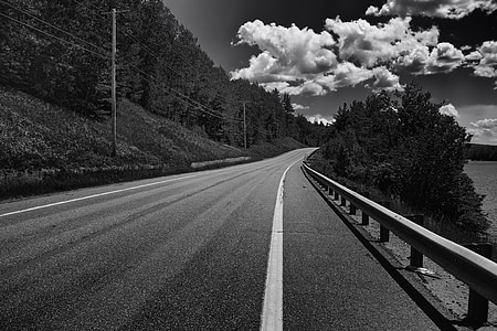 grayscale photography of road under skies thumbnail