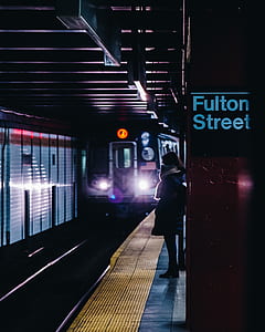 person standing beside Fulton Street train station thumbnail