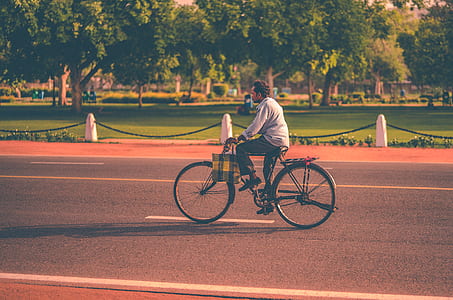 man riding bicycle on road during golden hour thumbnail