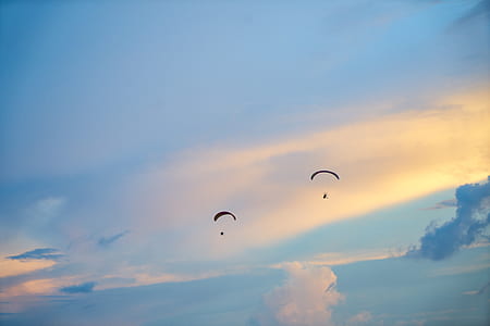 two persons doing paragliding during golden hour thumbnail