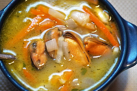 top view of mussel soup in black bowl thumbnail