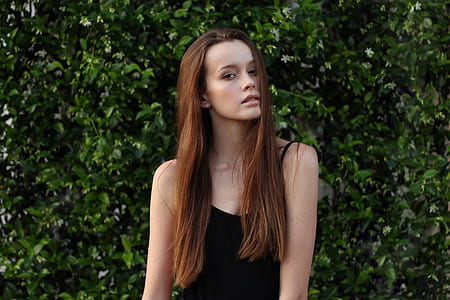 woman wearing black sleeveless top while being photograph thumbnail