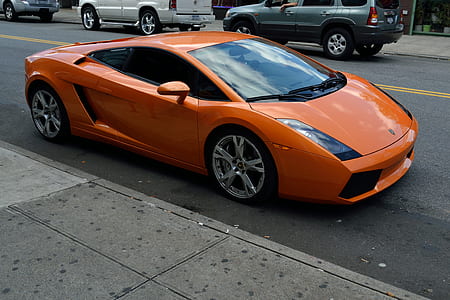 orange Lamborghini Gallardo parked on sidewalk thumbnail