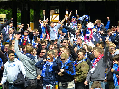 people gathering while wearing scarves and raising hands thumbnail