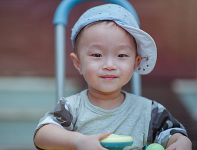 Depth of Field Photo of Boy Wearing Blue Cap thumbnail