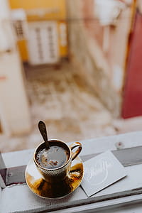 Drink coffee in a golden cup at the window thumbnail